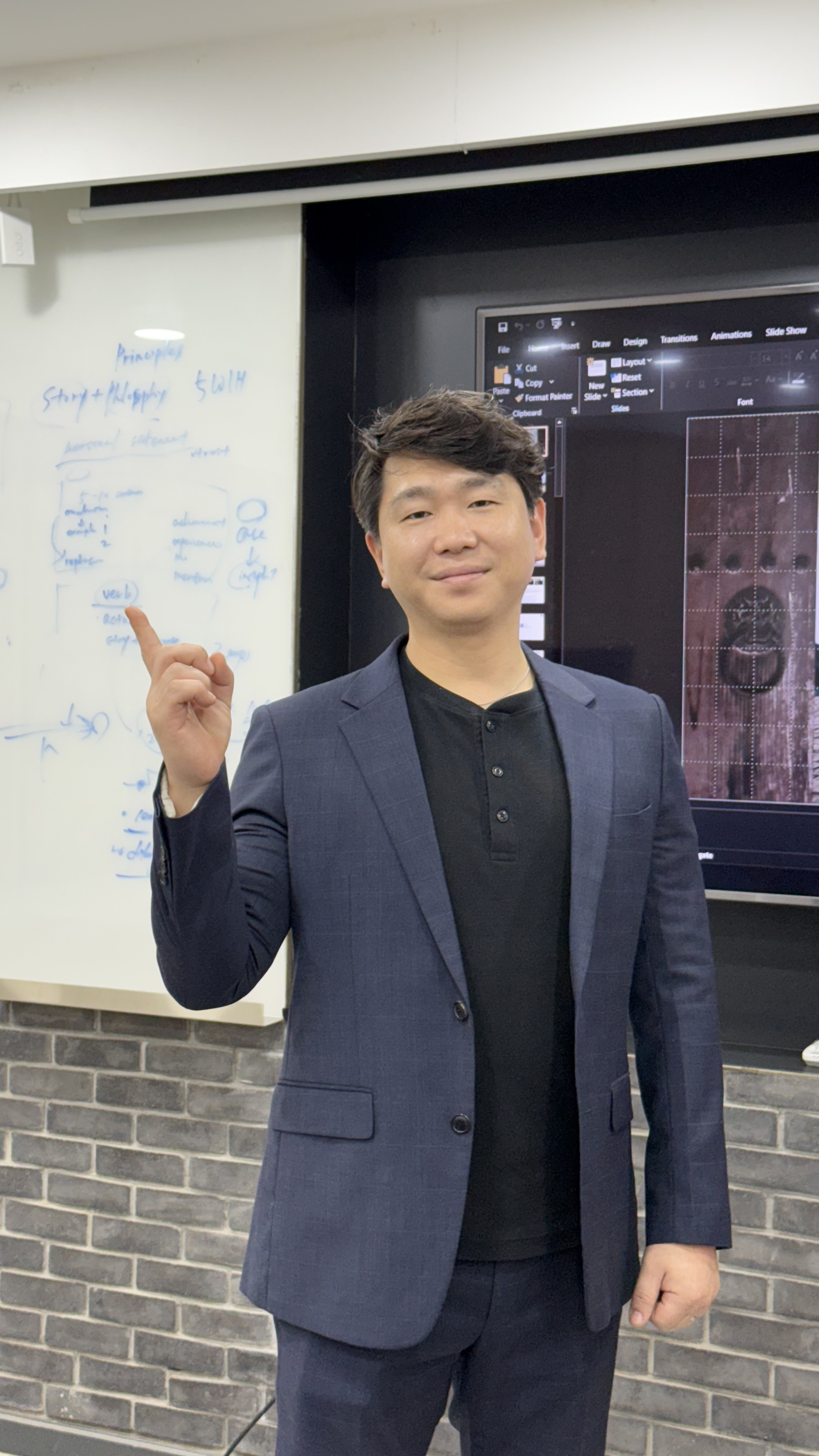 Seung Jung Kang teaching at a whiteboard during Korean business communication session